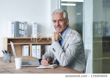Senior, businessman and smile, laptop and portrait at desk in the office for consultation. CEO, man and plan for budget, payroll and human resources and writing in company for startup proposal Senior, businessman and smile, laptop and portrait at desk in the office for consultation. CEO, man and plan for budget, payroll and human resources and writing in company for startup proposal 139809808
