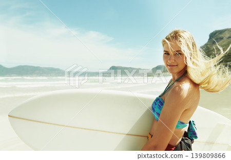 Portrait, wind and woman on beach with surfboard in summer for sports, travel or vacation on coast. Face, fitness and happy young surfer person on sand by sea or ocean for surfing hobby or leisure Portrait, wind and woman on beach with surfboard in summer for sports, travel or vacation on coast. Face, fitness and happy young surfer person on sand by sea or ocean for surfing hobby or leisure 139809866