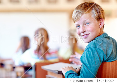 Child, portrait and school desk with notebook for education in teaching lesson or knowledge, development or scholarship. Boy, face and smile or writing in classroom for project, learning or studying Child, portrait and school desk with notebook for education in teaching lesson or knowledge, development or scholarship. Boy, face and smile or writing in classroom for project, learning or studying 139810002