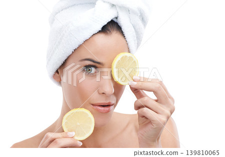 Woman, skincare and lemon in studio for facial beauty, cosmetics and natural product or vitamin c in portrait. Face of a young model with fruits for eye dermatology with towel on a white background Woman, skincare and lemon in studio for facial beauty, cosmetics and natural product or vitamin c in portrait. Face of a young model with fruits for eye dermatology with towel on a white background 139810065