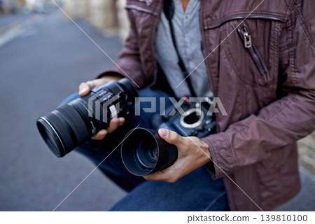 Camera lens, outdoor and hands of photographer to work in city on photoshoot with professional gear to film on street. Shooting, photography and cameraman closeup with tech to capture media in town Camera lens, outdoor and hands of photographer to work in city on photoshoot with professional gear to film on street. Shooting, photography and cameraman closeup with tech to capture media in town 139810100