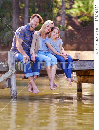 Portrait, lake and girl with family, smile and happiness with water or nature with vacation or getaway trip. Parents, hug or mother with father or child in a forest or holiday with boardwalk or relax Portrait, lake and girl with family, smile and happiness with water or nature with vacation or getaway trip. Parents, hug or mother with father or child in a forest or holiday with boardwalk or relax 139810191