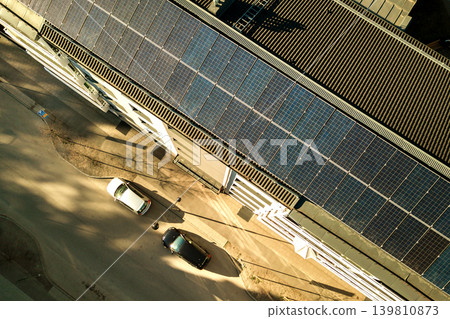 Aerial view of solar photovoltaic panels on a roof top of residential building block for producing clean electric energy. Autonomous housing concept. Aerial view of solar photovoltaic panels on a roof top of residential building block for producing clean electric energy. Autonomous housing concept. 139810873