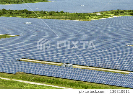 Aerial view of large sustainable electrical power plant with rows of solar photovoltaic panels for producing clean electric energy. Concept of renewable electricity with zero emission Aerial view of large sustainable electrical power plant with rows of solar photovoltaic panels for producing clean electric energy. Concept of renewable electricity with zero emission 139810911