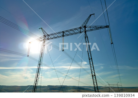 High voltage tower with electric power lines transfening electrical energy through cable wires High voltage tower with electric power lines transfening electrical energy through cable wires 139810934