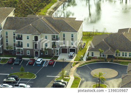 Aerial view of american apartment buildings in Florida residential area. New family condos as example of housing development in US suburbs Aerial view of american apartment buildings in Florida residential area. New family condos as example of housing development in US suburbs 139810987