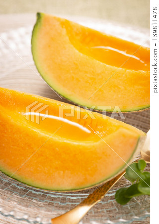 A cross-section of a fresh and juicy cantaloupe, showcasing its beautiful yellow flesh. A cross-section of a fresh and juicy cantaloupe, showcasing its beautiful yellow flesh. 139811478
