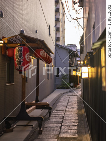 Lanterns and paper lanterns of Minami Kannon-yama illuminate the alleys of Kyoto. A picturesque scene unfolds along the cobblestone streets. Lanterns and paper lanterns of Minami Kannon-yama illuminate the alleys of Kyoto. A picturesque scene unfolds along the cobblestone streets. 139812002
