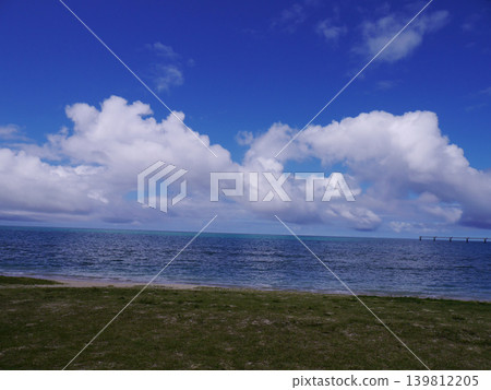 Green grass, the vast blue sea, and white clouds – Senaga Island, Tomigusuku City, Okinawa Prefecture Green grass, the vast blue sea, and white clouds – Senaga Island, Tomigusuku City, Okinawa Prefecture 139812205