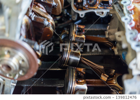 Closeup of engine pistons connecting rods inside automotive motor highlighting mechanical engineering repair maintenance Closeup of engine pistons connecting rods inside automotive motor highlighting mechanical engineering repair maintenance 139812476