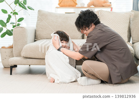 一位父親正在用毛巾為剛洗完澡的孩子擦乾身體。 139812936
