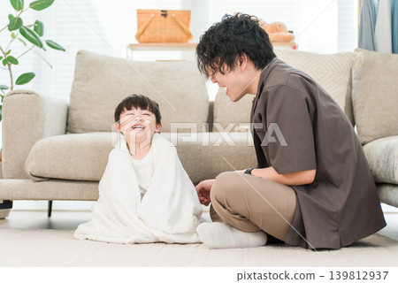 一位父親正在用毛巾為剛洗完澡的孩子擦乾身體。 139812937