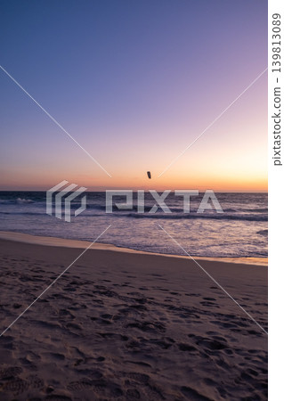 Sunset view of Scarborough Beach in Perth, Australia. with silhouette of a person kitesurfing or skysurfing, surf with a parachute 139813089