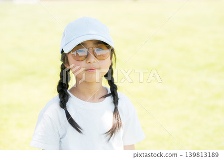 一個戴著太陽眼鏡的女孩在公園玩耍 139813189