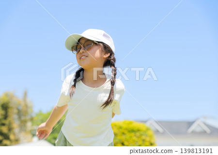 A girl playing in the park wearing sunglasses A girl playing in the park wearing sunglasses 139813191