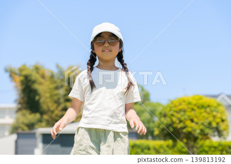 A girl playing in the park wearing sunglasses 139813192