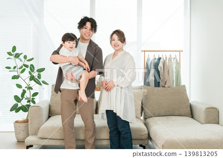 一對年輕的亞洲夫婦在家中抱著孩子，家庭，父母和孩子，家庭 139813205