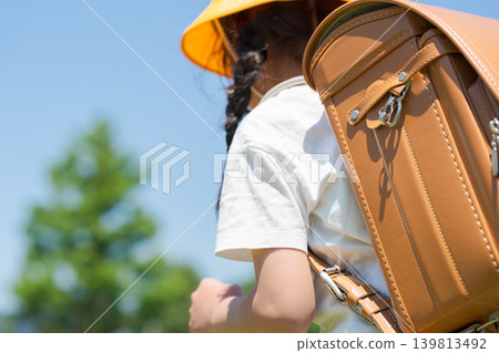 Elementary school student carrying a school bag Elementary school student carrying a school bag 139813492