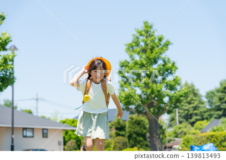 A girl with a schoolbag on her back running in a hurry A girl with a schoolbag on her back running in a hurry 139813493