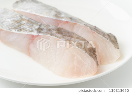 Close-up of a slice of cod (uncooked) on a plate. Close-up of a slice of cod (uncooked) on a plate. 139813650
