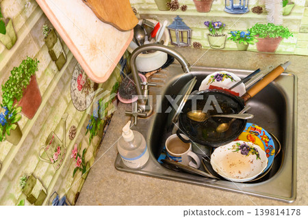 top angle view of a sink full of dirty dishes top angle view of a sink full of dirty dishes 139814178