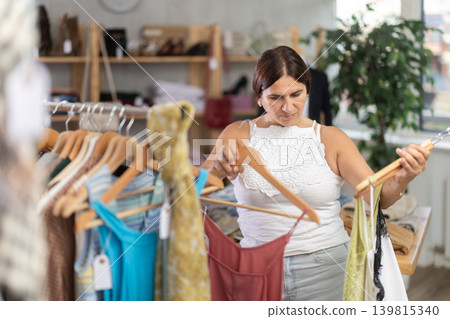 Latin woman customer turn over and choose something summer cloth in store, Latin woman customer turn over and choose something summer cloth in store, 139815340