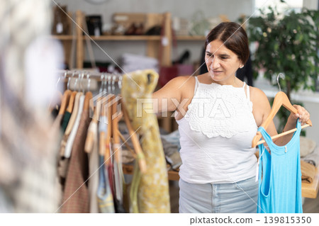 Latin woman customer turn over and choose something summer cloth in store, Latin woman customer turn over and choose something summer cloth in store, 139815350