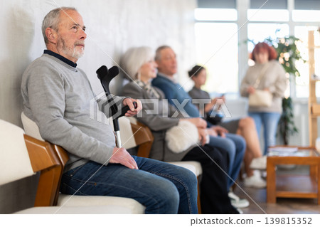 Elderly man waiting in line during visit to medical center Elderly man waiting in line during visit to medical center 139815352