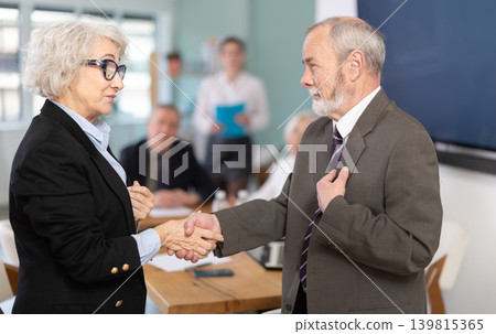 Man and woman shake hands in gratitude after signing a contract at business meeting Man and woman shake hands in gratitude after signing a contract at business meeting 139815365