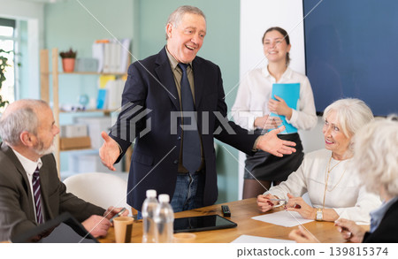 Senior male speaker shares happy news, makes participants laugh Senior male speaker shares happy news, makes participants laugh 139815374