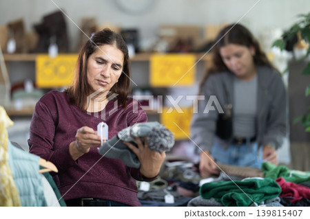 Latina woman choosing hat in clothing store Latina woman choosing hat in clothing store 139815407