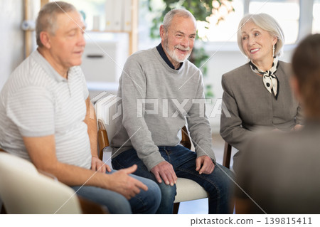 Engaged elderly people sitting in a circle and talking Engaged elderly people sitting in a circle and talking 139815411