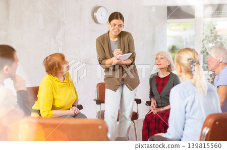 Young female psychologist doing group therapy in nursing home for the elderly Young female psychologist doing group therapy in nursing home for the elderly 139815560
