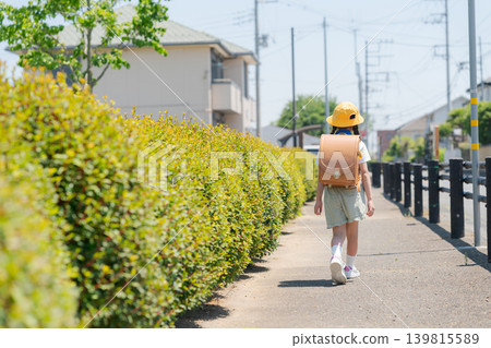一個女孩背著書包的背影。 一個女孩背著書包的背影。 139815589