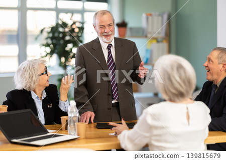 Senior male speaker shares happy news, makes participants laugh Senior male speaker shares happy news, makes participants laugh 139815679