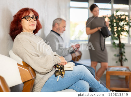 People of different ages sit and wait in line waiting to see social worker 139815849