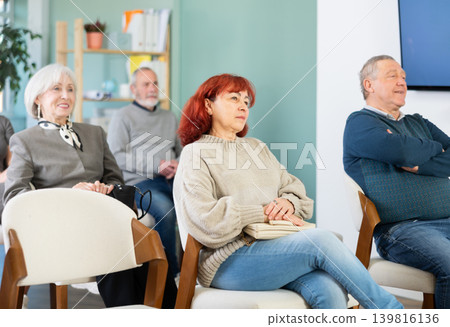 Focused group of students of different ages sitting on chairs and listening lecture in lecture hall Focused group of students of different ages sitting on chairs and listening lecture in lecture hall 139816136