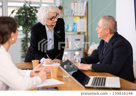 Senior business community listening to female speaker or presenter during round table conference. Senior business community listening to female speaker or presenter during round table conference. 139816146