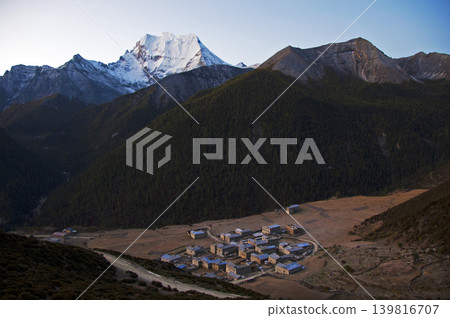 An aerial view of the mountain village of Inagi Yading, overlooking snow-capped mountains. An aerial view of the mountain village of Inagi Yading, overlooking snow-capped mountains. 139816707