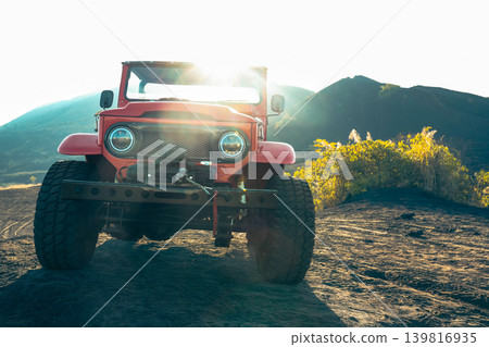 Classic jeep drives on volcanic terrain under the sun in Bali Classic jeep drives on volcanic terrain under the sun in Bali 139816935