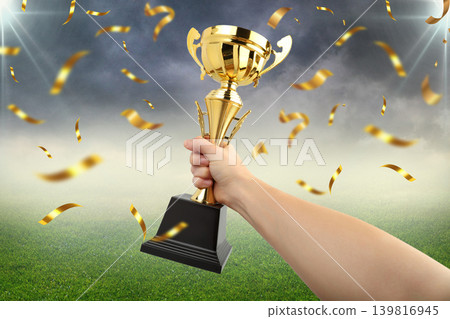 Hand grips trophy as confetti falls during sports event 139816945