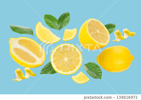 Lemon slices and whole fruits with green leaves scattered 139816972