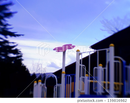 Park playground equipment adorned with flower motifs that stand out against the blue sky. 139816982