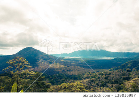 View of mountains and a lake surrounded by trees in Bali View of mountains and a lake surrounded by trees in Bali 139816997