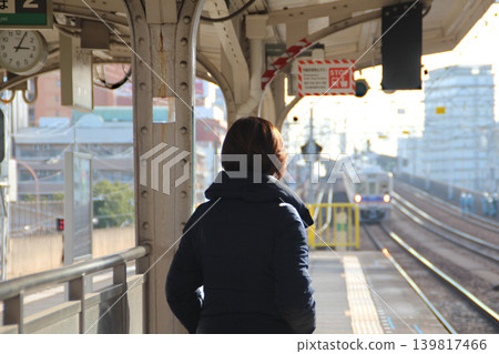 A woman waiting for a train 139817466