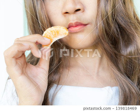 Woman eating orange fruit close up, breakfas in morning, food for diet and good health lifestyle, fruit citrus natural hight vitamin C 139818469