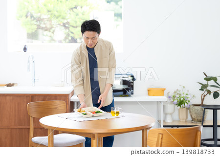 A man eating a microwaveable delivery meal. A man eating a microwaveable delivery meal. 139818733