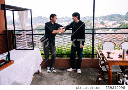 Two Southeast Asian men talking together outside in casual setting Two Southeast Asian men talking together outside in casual setting 139819096