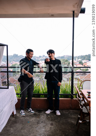 Southeast Asian male friends pointing toward camera in outdoor setting Southeast Asian male friends pointing toward camera in outdoor setting 139819099