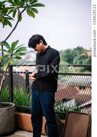 Asian man suffering from stomachache in outdoor setting Asian man suffering from stomachache in outdoor setting 139819113